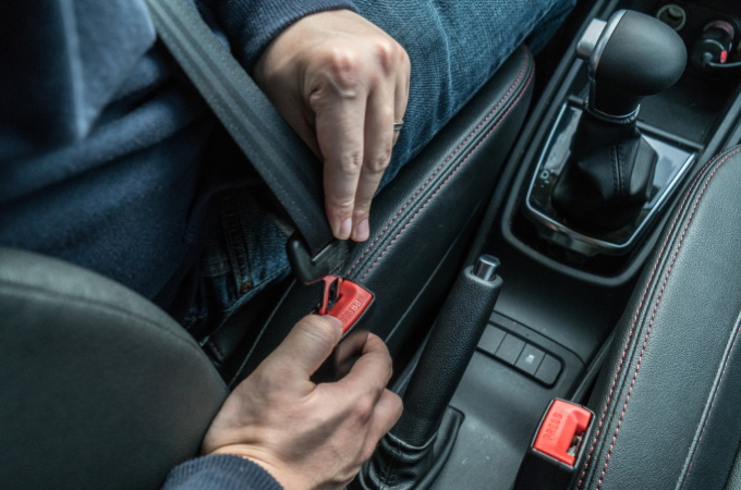 Men's hand fastens the seat belt of the car. Close your car seat belt while sitting inside the car before driving and take a safe journey. Closeup shot of male driver fastens seat belt.